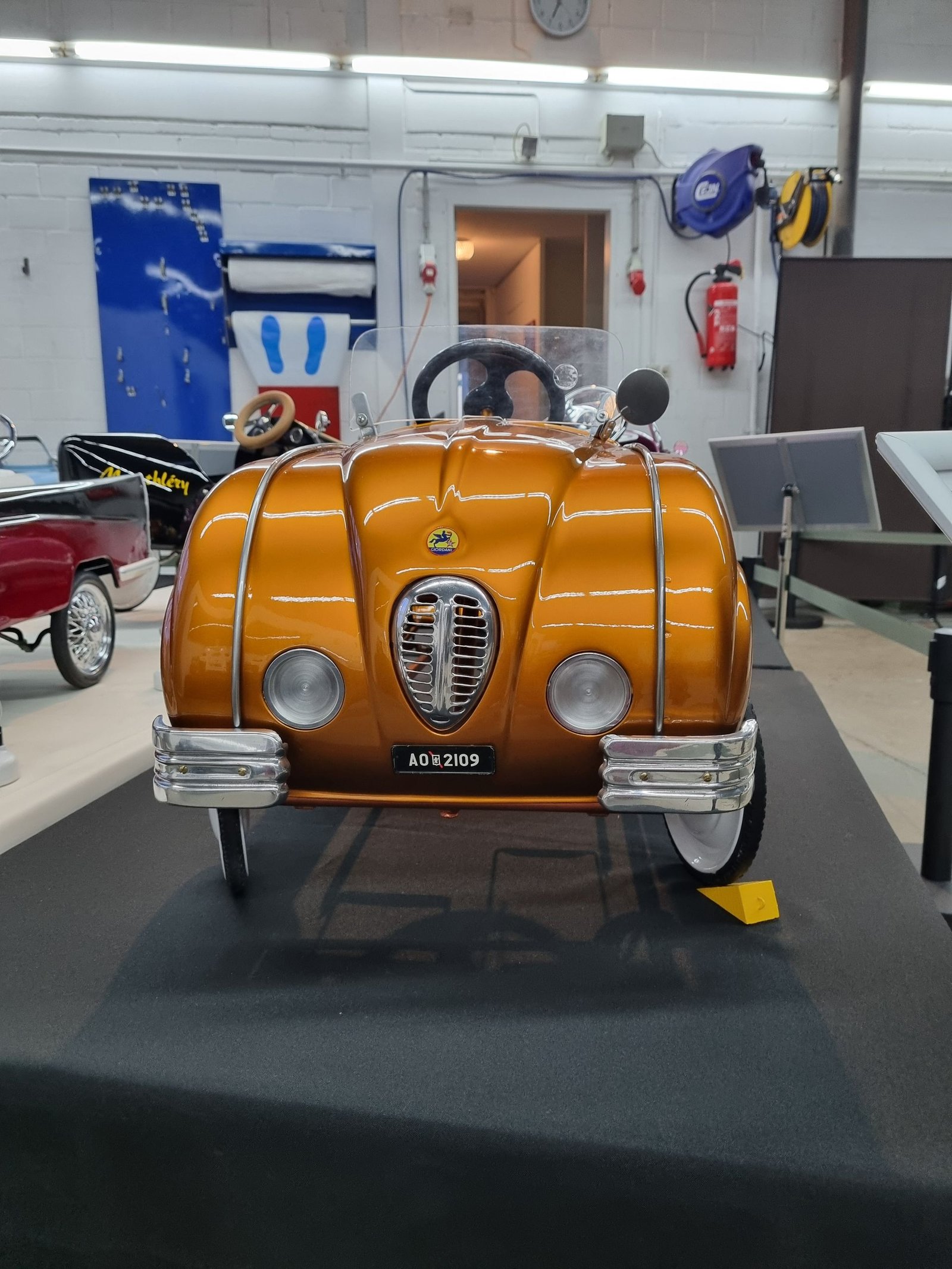 Ein gelbes Tretauto mit einem Nummernschild mit der Aufschrift „jdp38“